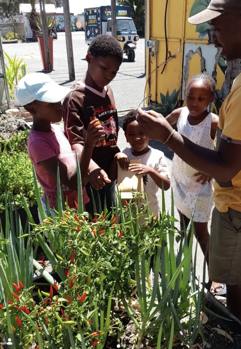 A local guide showing children around a garden