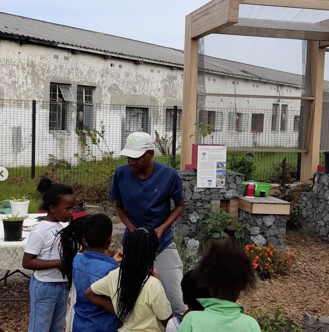 A guide sharing knowledge with children in a garden