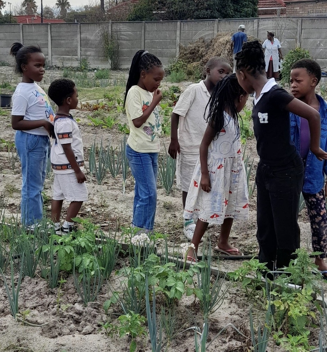 Children exploring a community herb garden