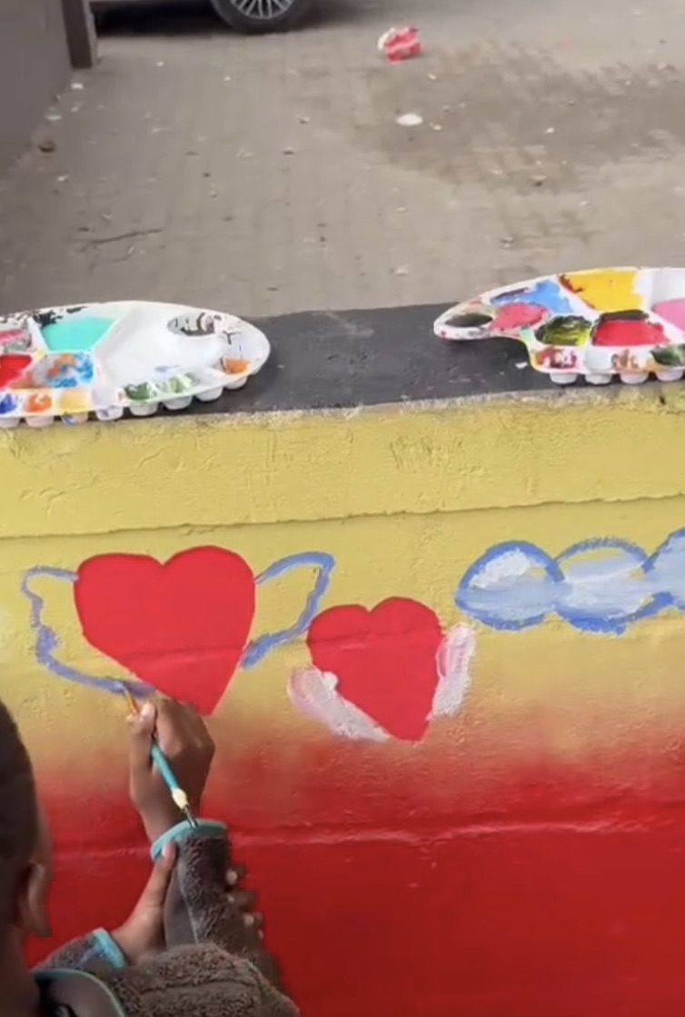 Children painting a colorful community wall